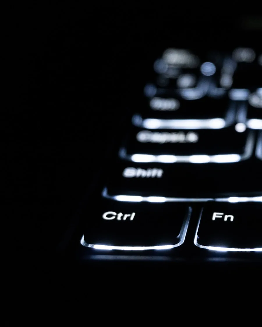 Backlit keyboard keys glowing in a dark room, mid write-up