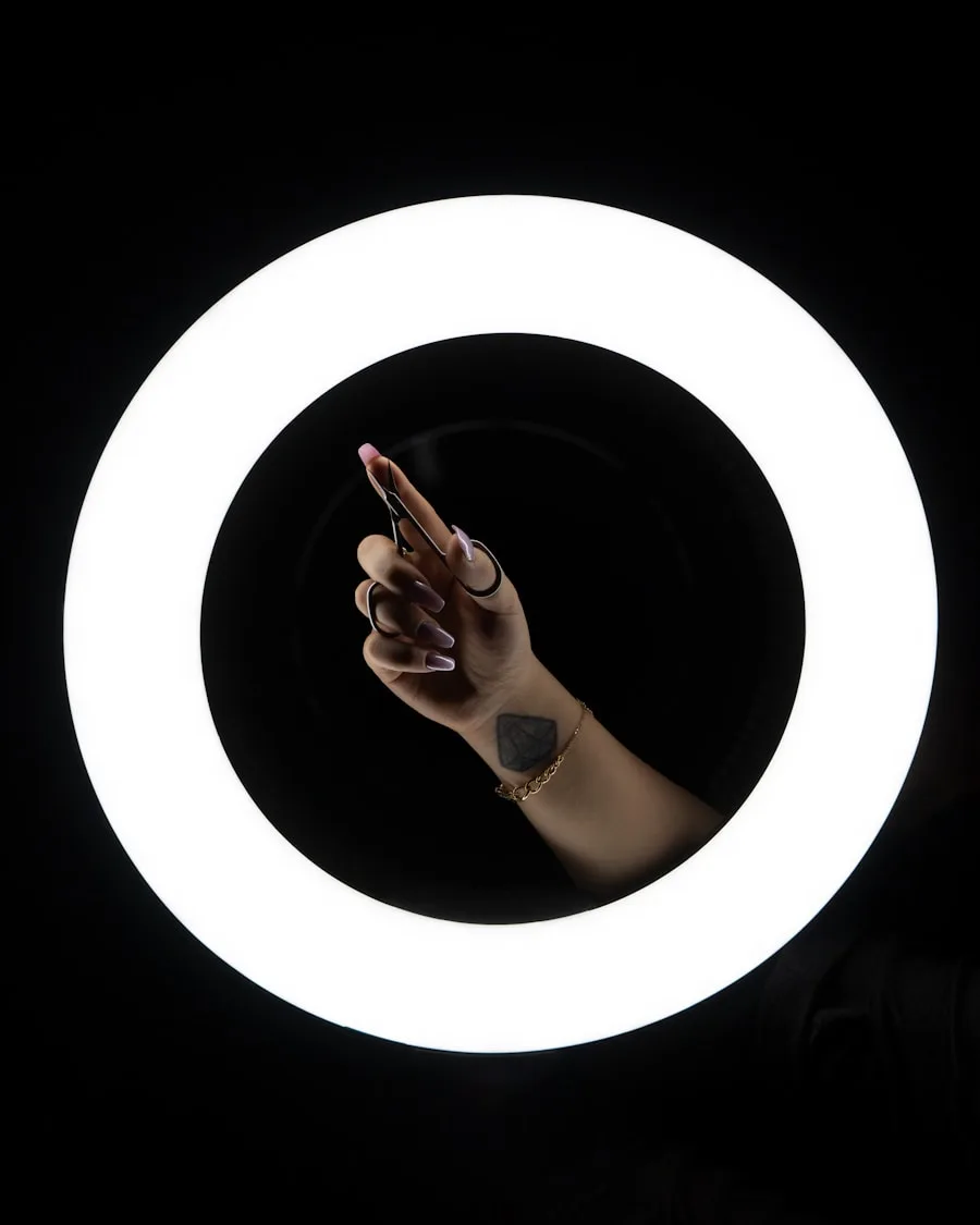 A creator's hand reaching into a ring light, about to start filming